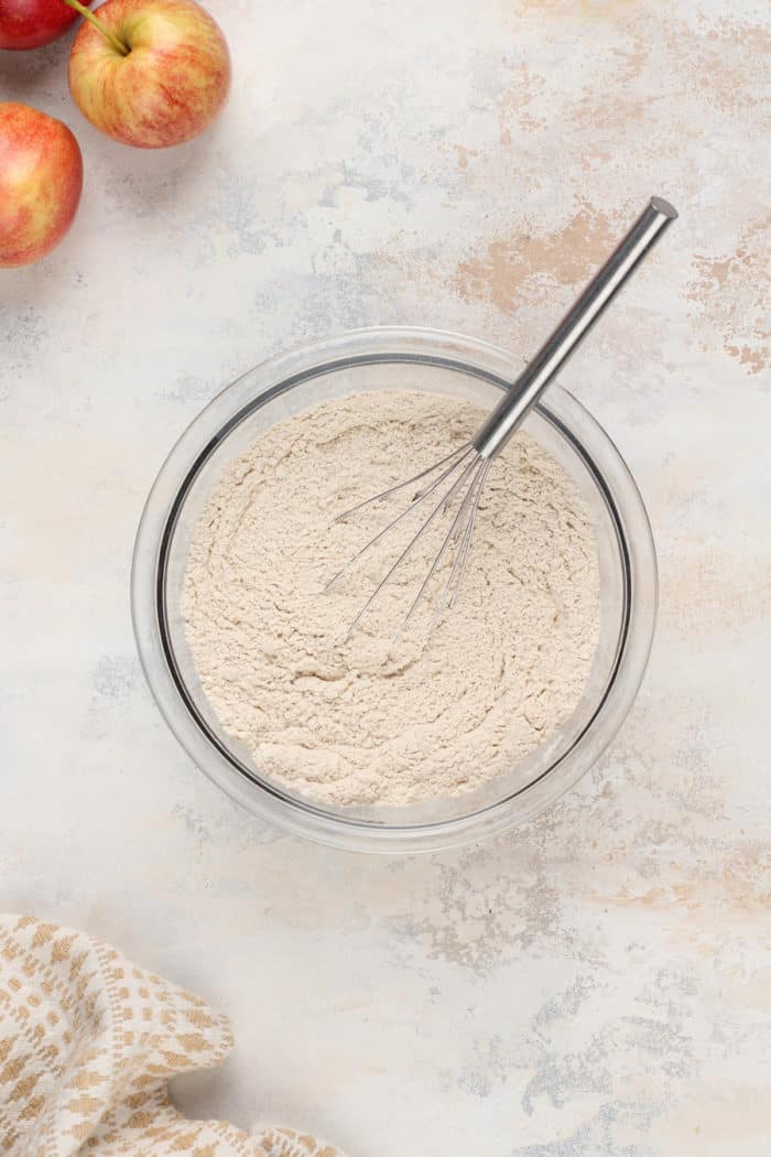 Dry ingredients for apple cider blondies being whisked in a glass bowl.