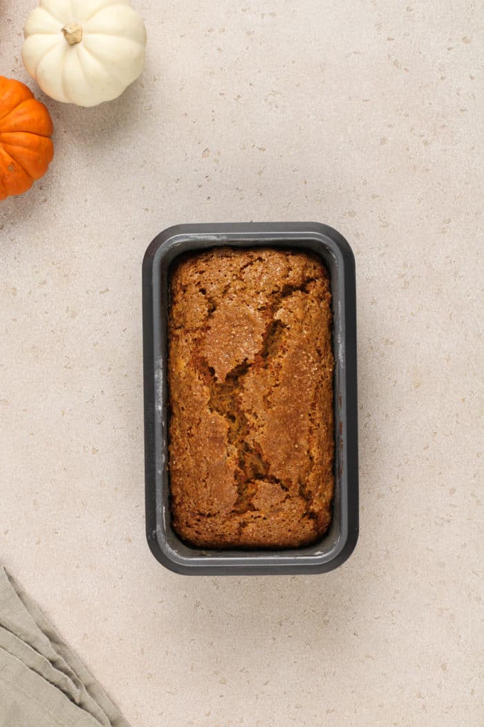 Baked loaf of pumpkin banana bread in a loaf pan.