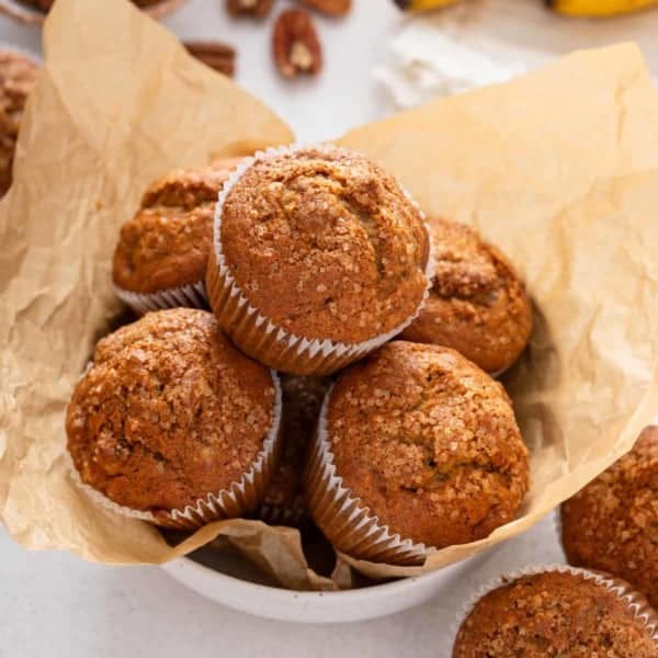 Banana nut muffins in a parchment-lined bowl.