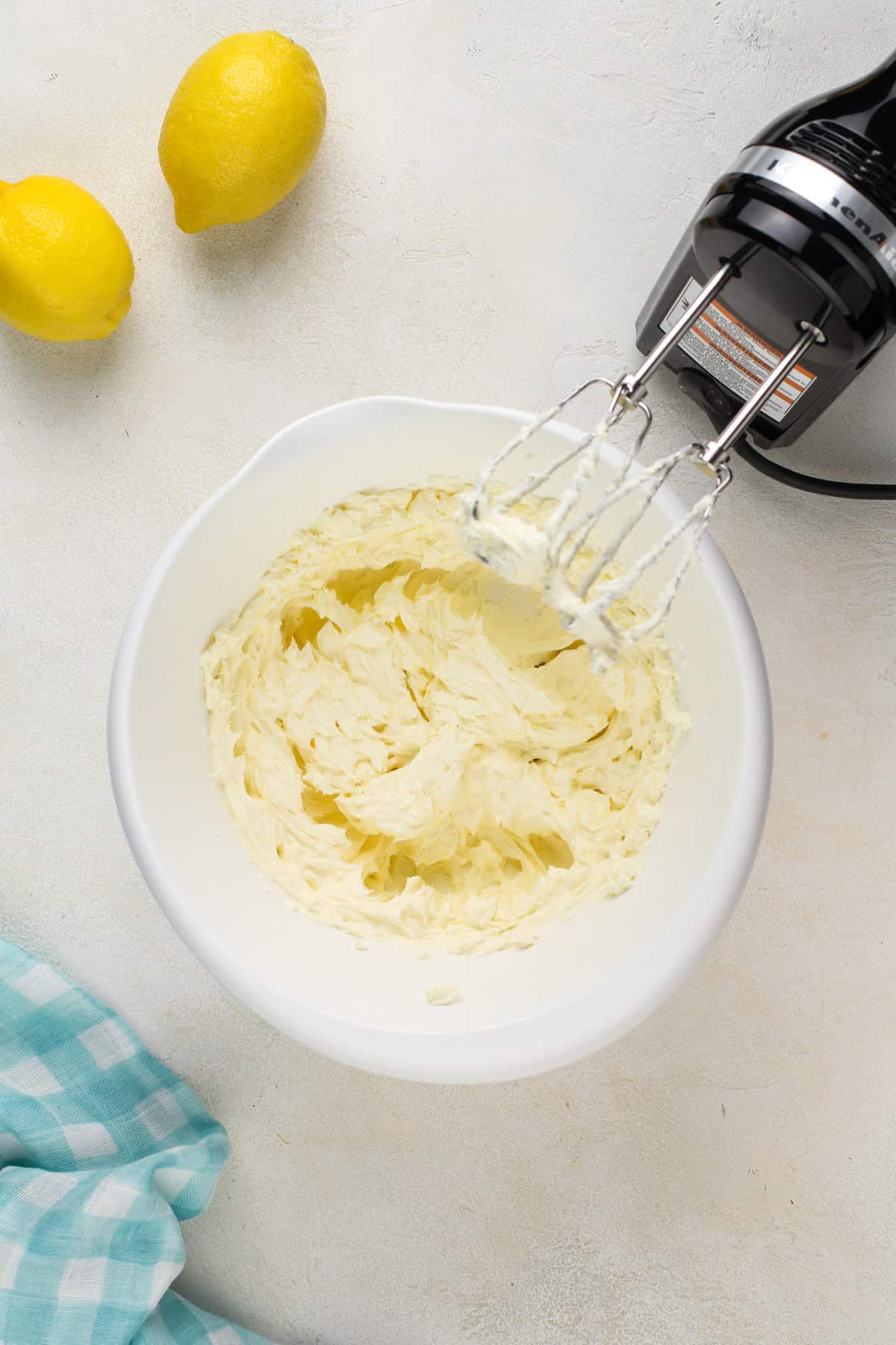 Beaten cream cheese in a white mixing bowl.