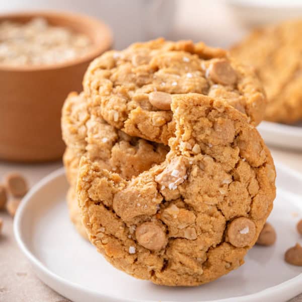 Bite from a peanut butter oatmeal cookie on a white plate.