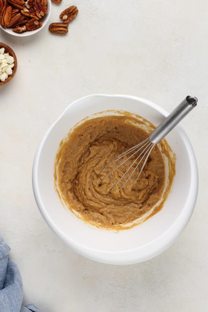 Butter and brown sugar mixed together in a white mixing bowl.