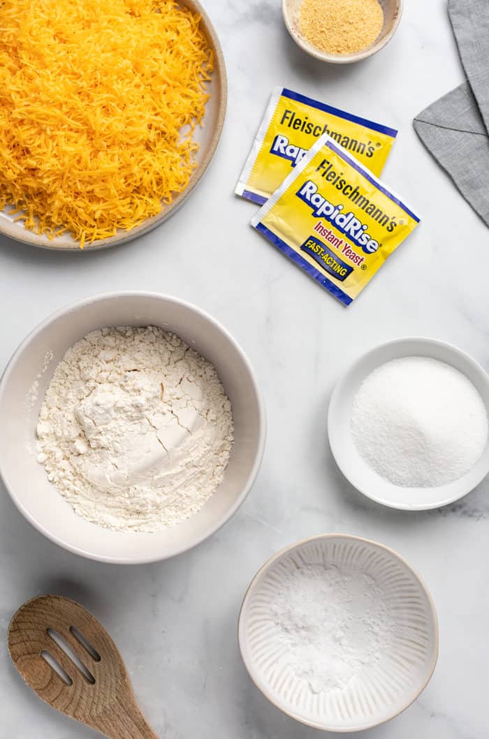 Ingredients for cheddar dinner rolls on a marble countertop