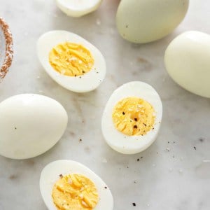 Close up of several hard boiled egg halves on a marble surface