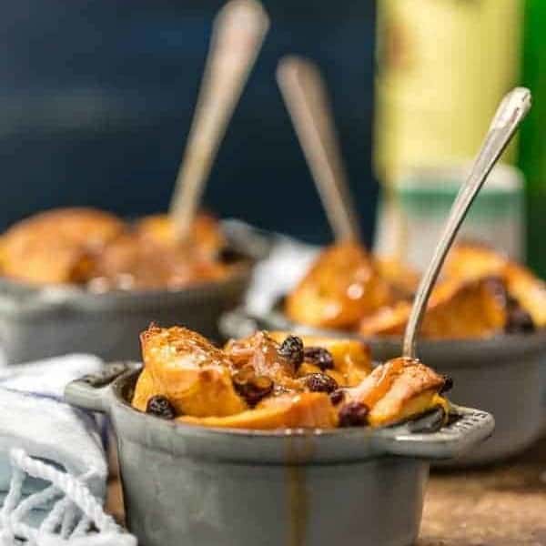 Spoon in a ramekin of irish bread pudding topped with whiskey caramel sauce.