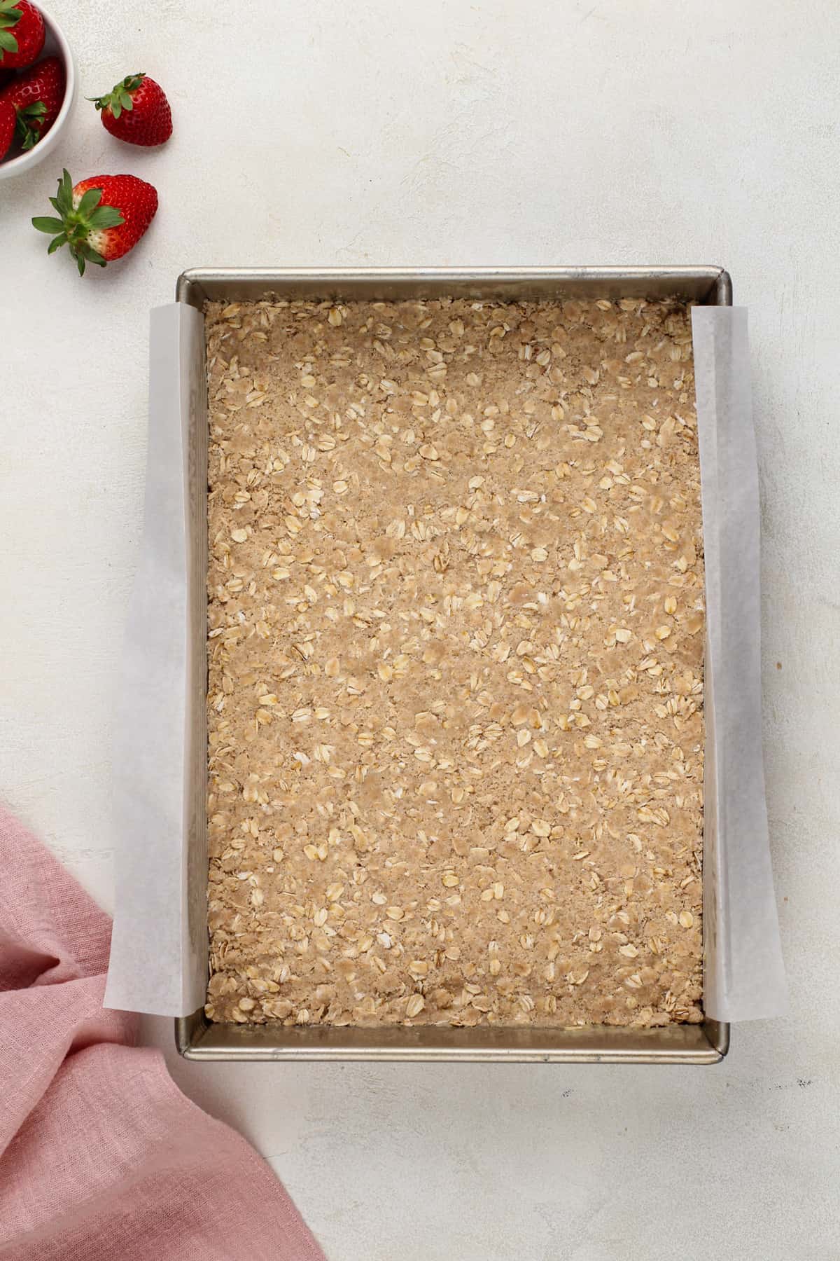 Crust mixture for oat bars pressed into the bottom of a 9x13-inch pan.