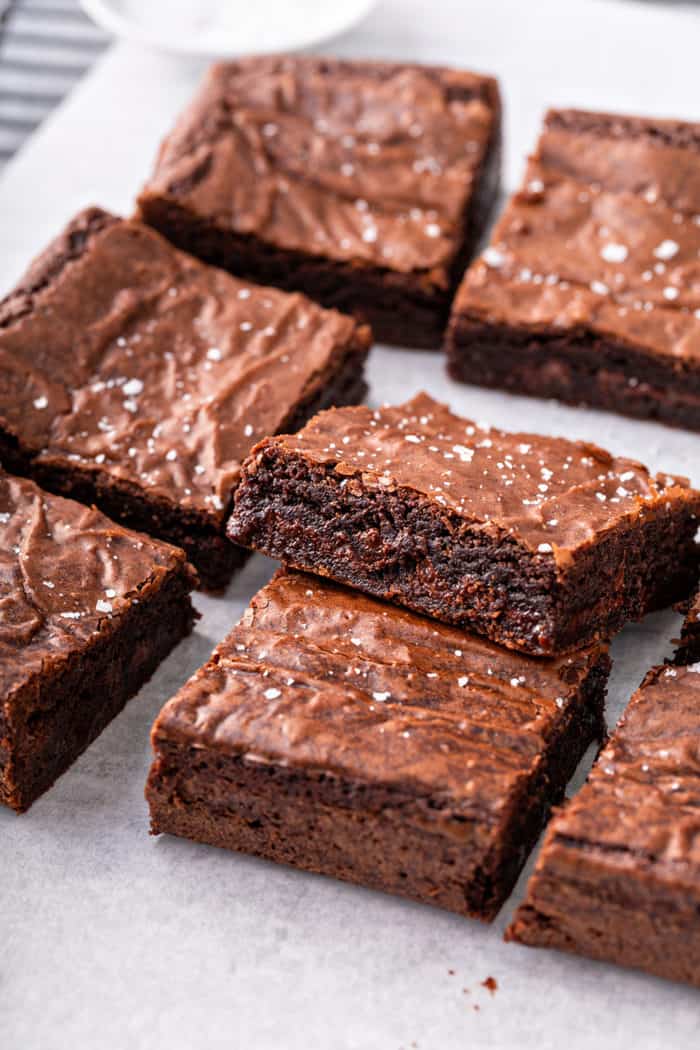 Sliced salted caramel brownies on a piece of parchment paper