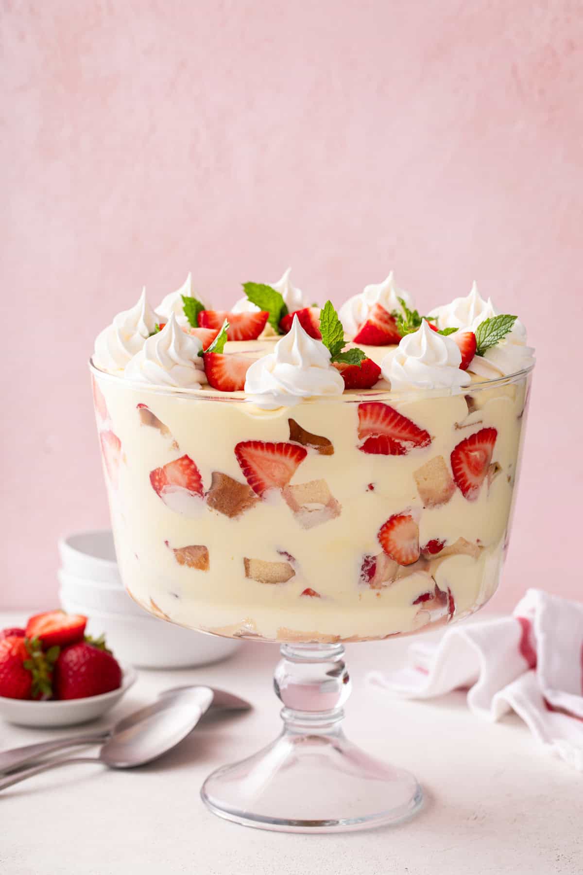 Side view of strawberry trifle in a trifle dish.