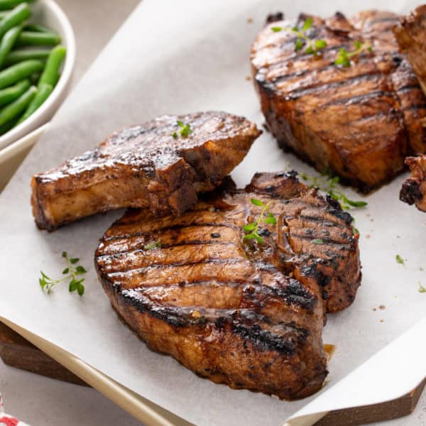 Grilled pork chops resting on a sheet pan.