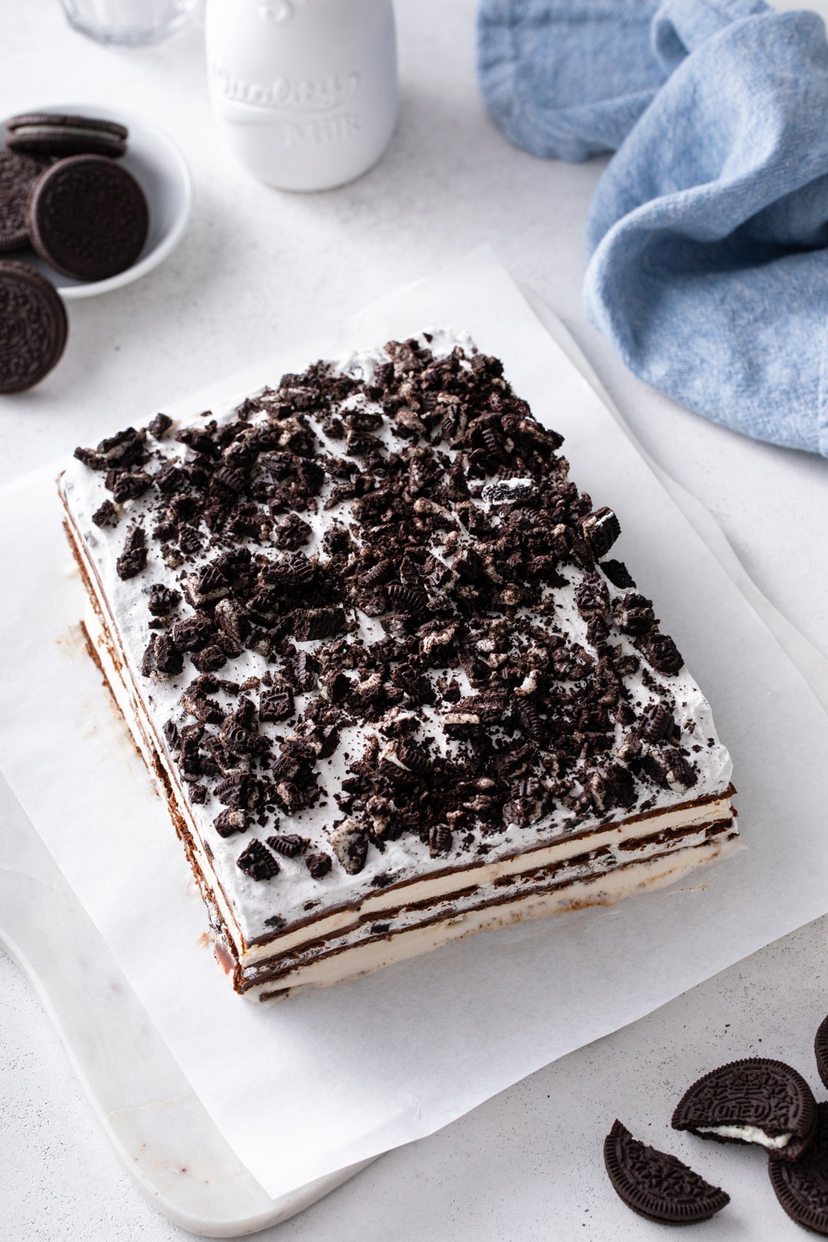 Frozen ice cream sandwich cake on a slice of parchment paper, ready to be sliced and served.