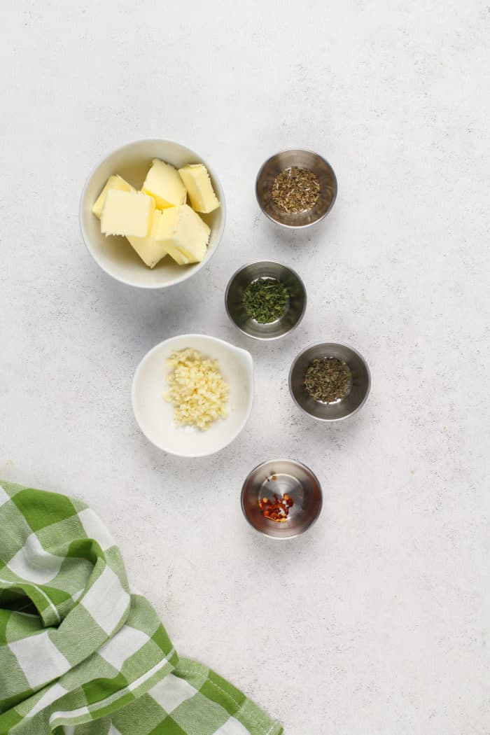 Garlic and herb butter ingredients arranged on a countertop.