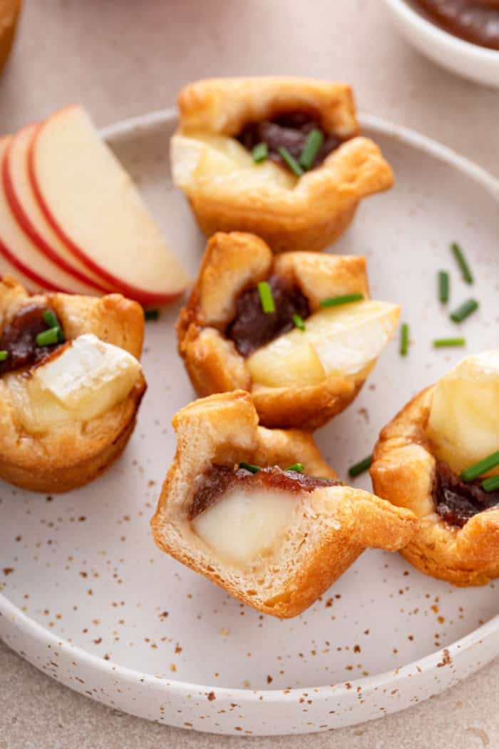 Plate filled with apple butter brie bites. One of the bites is cut in half.