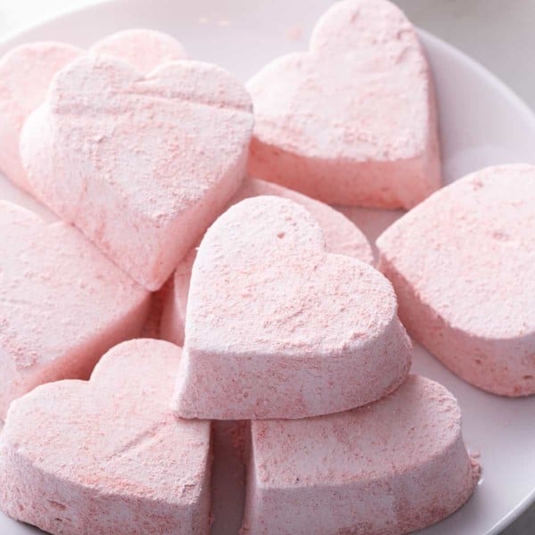 Heart-shaped strawberry marshmallows on a white plate.