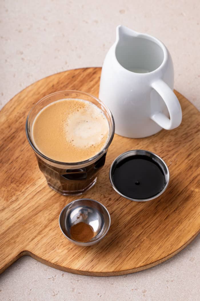 Ingredients for iced shaken espresso on a wooden board.