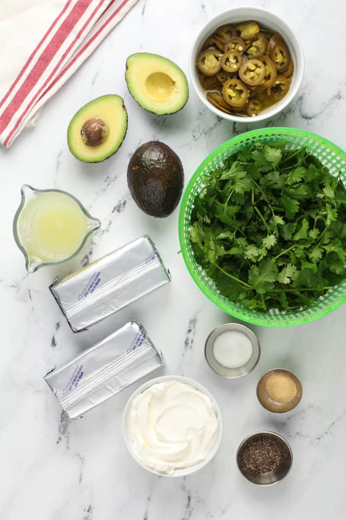 Jalapeño dip ingredients arranged on a marble countertop.