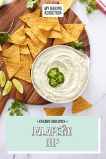 Bowl filled with jalapeño dip on a round wooden board scattered with tortilla chips. Text overlay includes recipe name.