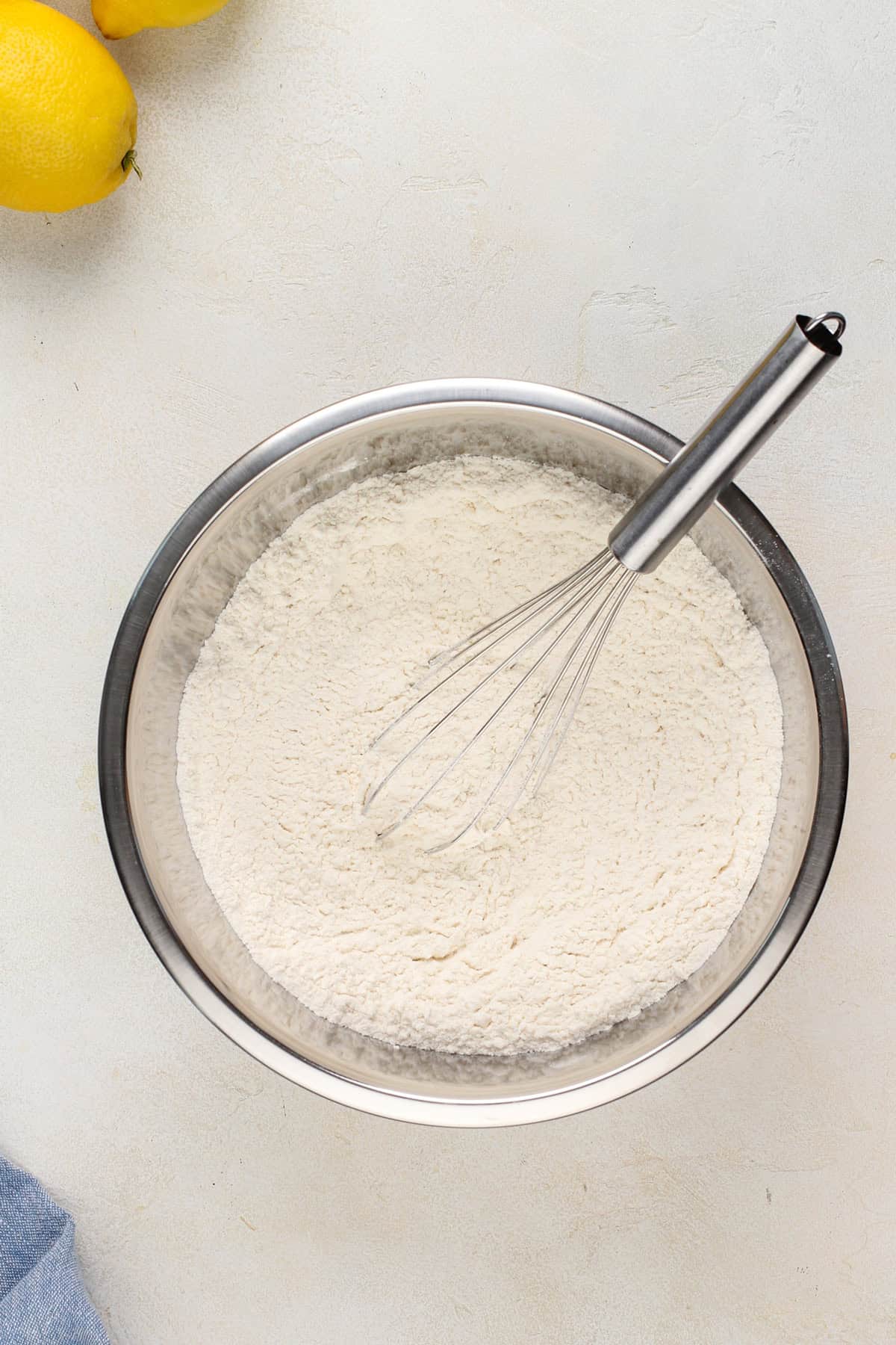 Dry ingredients for lemon cookies in a metal bowl.