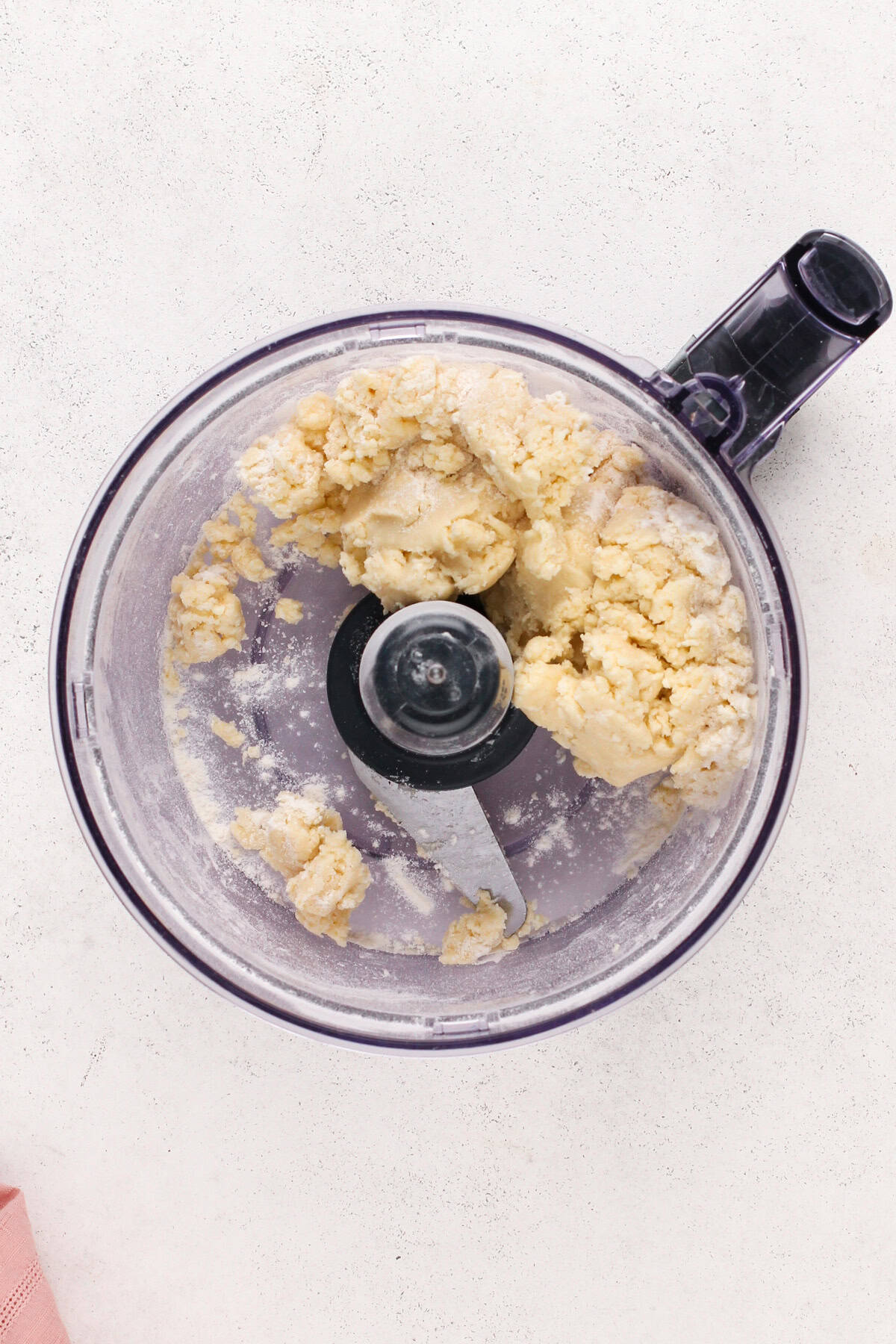 Tart dough in the bowl of a food processor.