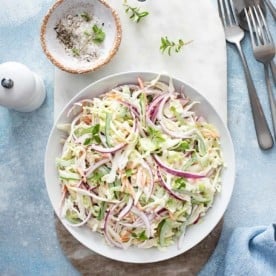 Serving bowl filled with easy coleslaw on a blue countertop