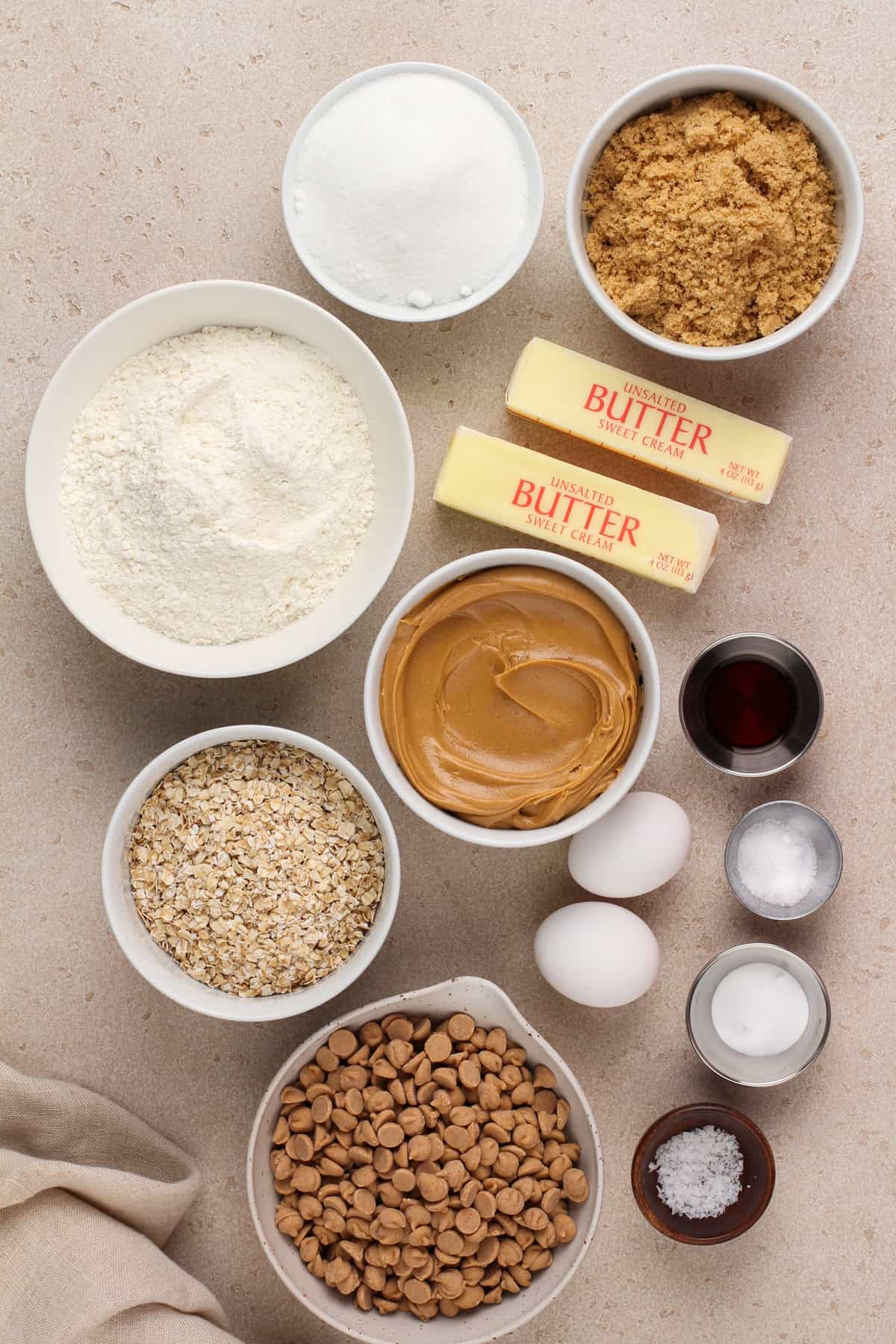 Ingredients for peanut butter oatmeal cookies arranged on a beige countertop.