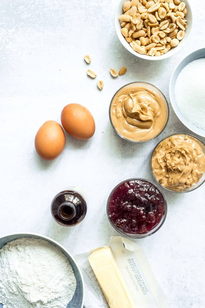 Overhead view of the ingredients for peanut butter and jelly bars on a marble countertop