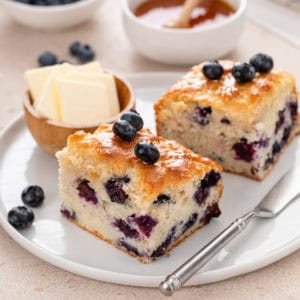 Two blueberry biscuits on a white plate.