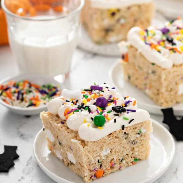 Plated halloween rice krispie treats next to a glass of milk