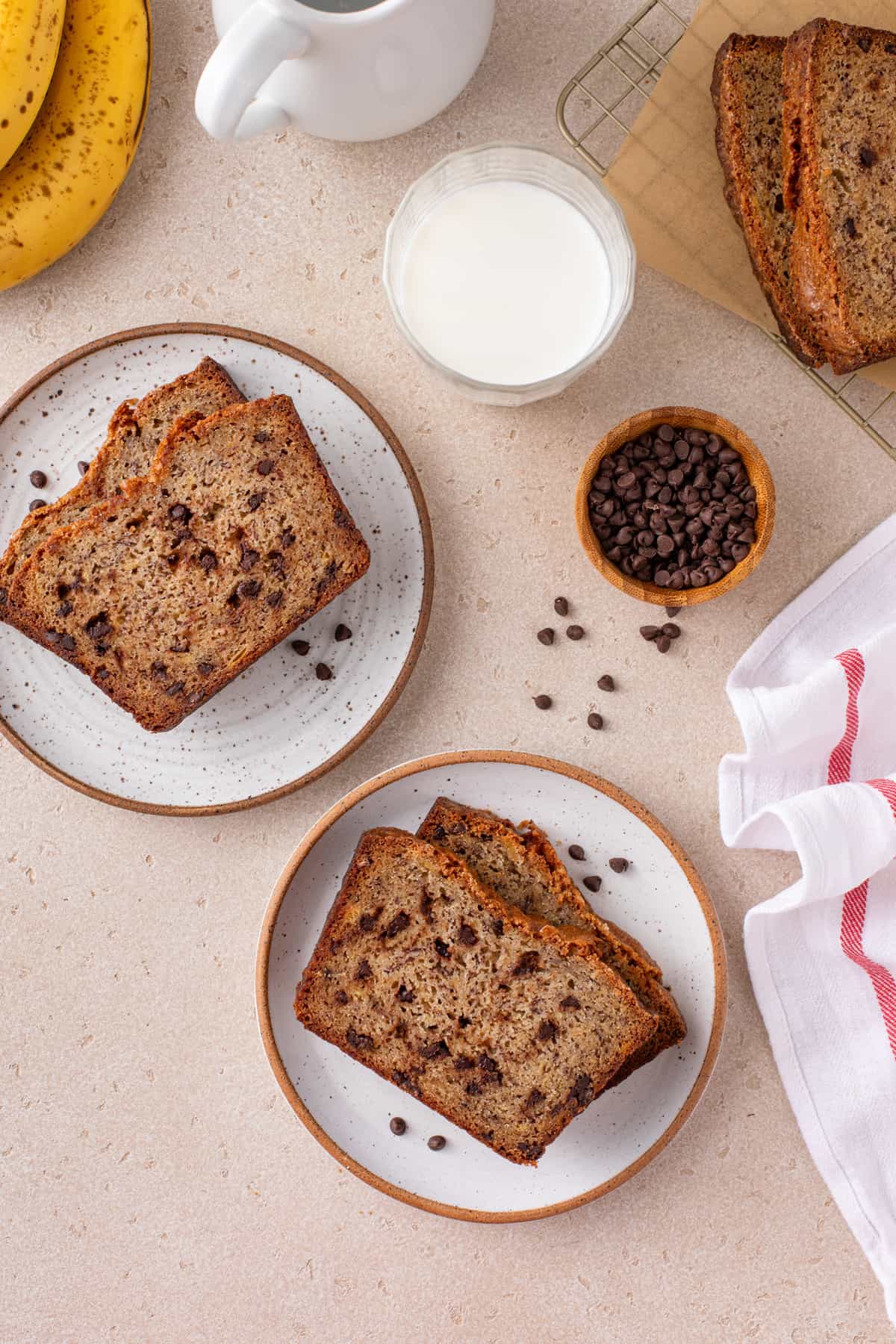 Overhead view of two plates, each holding slices of chocolate chip banana bread.