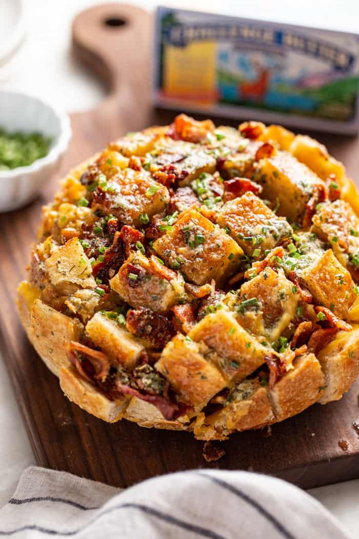 A loaf of baked cheesy ranch pull-apart bread on a wooden cutting board