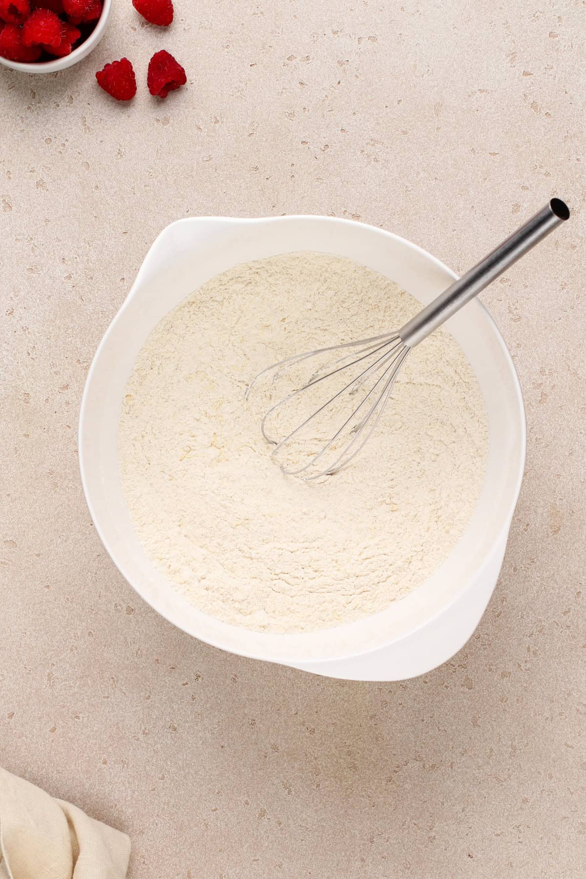 Dry ingredients for lemon raspberry muffins in a large bowl.