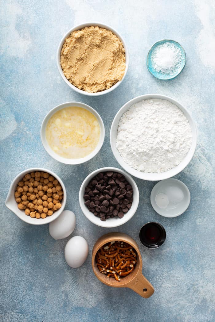 Ingredients for salted caramel blondies with pretzels on a blue countertop