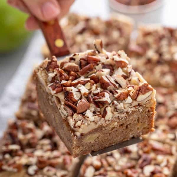 Cake server holding a caramel apple blondie up to the camera.