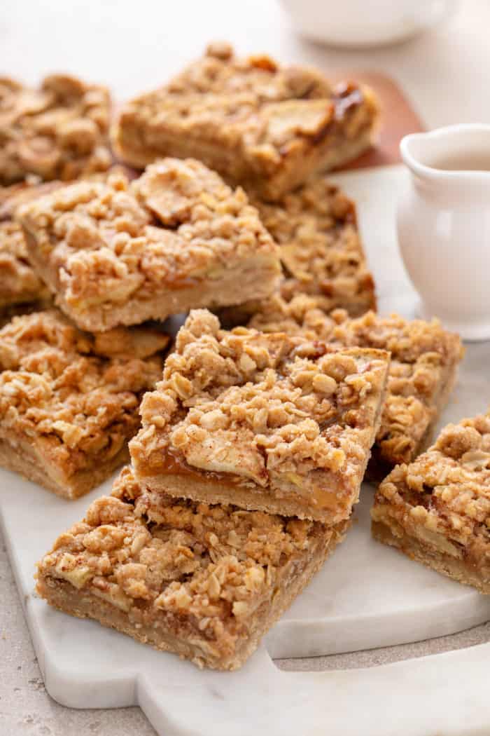 Sliced apple crisp bars arranged on a marble board.