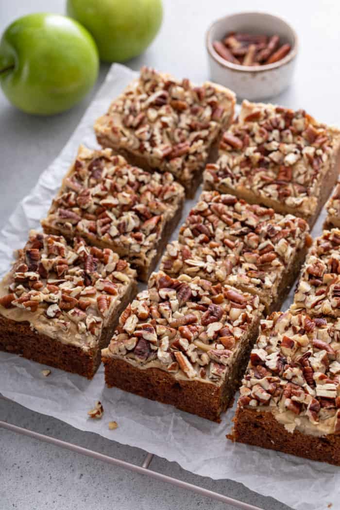 Sliced caramel apple blondies on a piece of parchment paper.