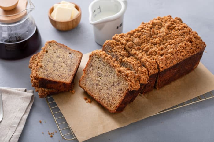 Sliced loaf of brown butter banana bread on a piece of parchment paper.