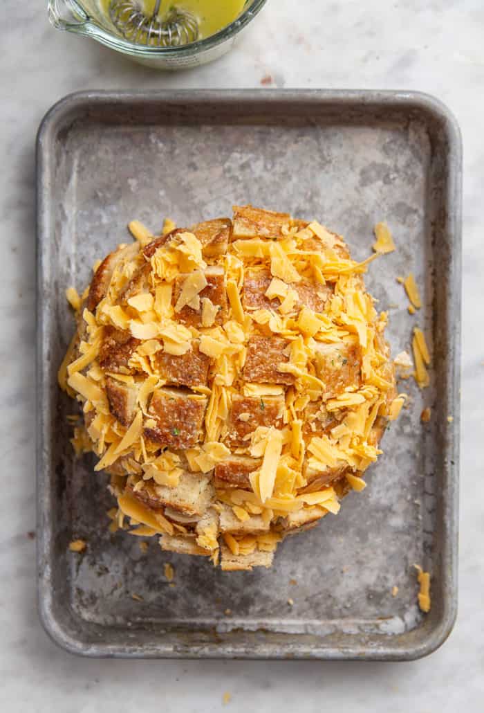 Sliced sourdough boule stuffed with shredded cheddar cheese