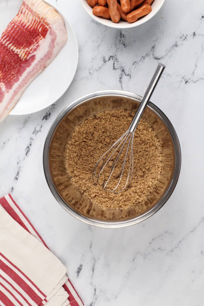 Brown sugar mixed together with spices in a metal mixing bowl.