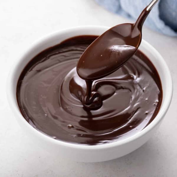 Bowl of chocolate ganache with a spoon in it.