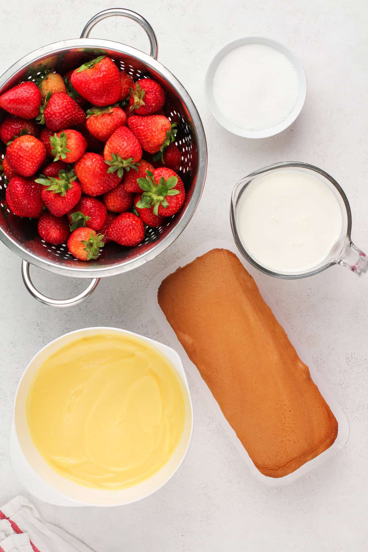 Strawberry trifle ingredients arranged on a countertop.