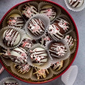 Cookie tin filled with Peppermint oreo balls on a gray counter