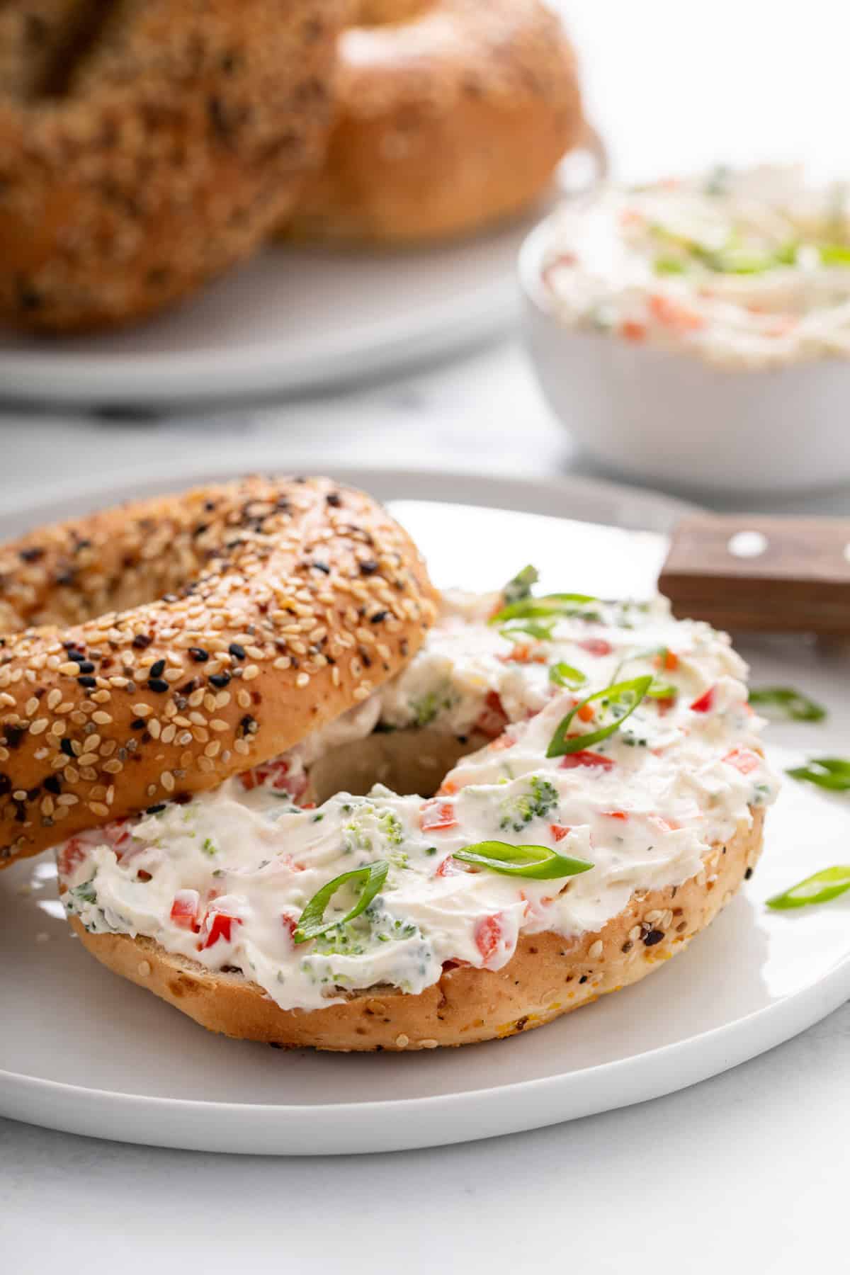 Everything bagel spread with veggie cream cheese on a white plate.