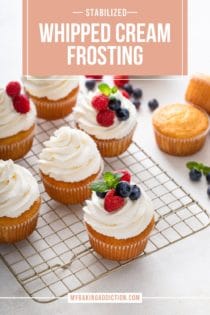 Vanilla cupcakes topped with whipped cream frosting and fresh berries scattered on a wire cooling rack. Text overlay includes recipe name.