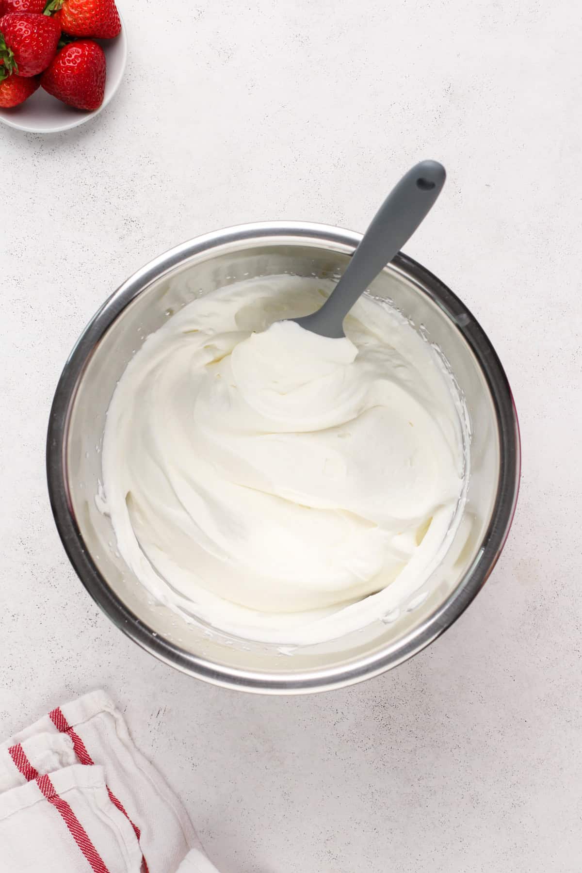 Whipped cream in a metal bowl.